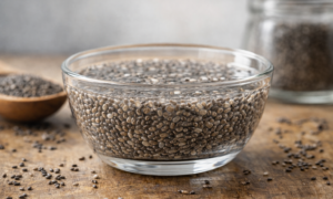 sementes de chia hidratadas em recipiente de vidro sobre superfície de madeira